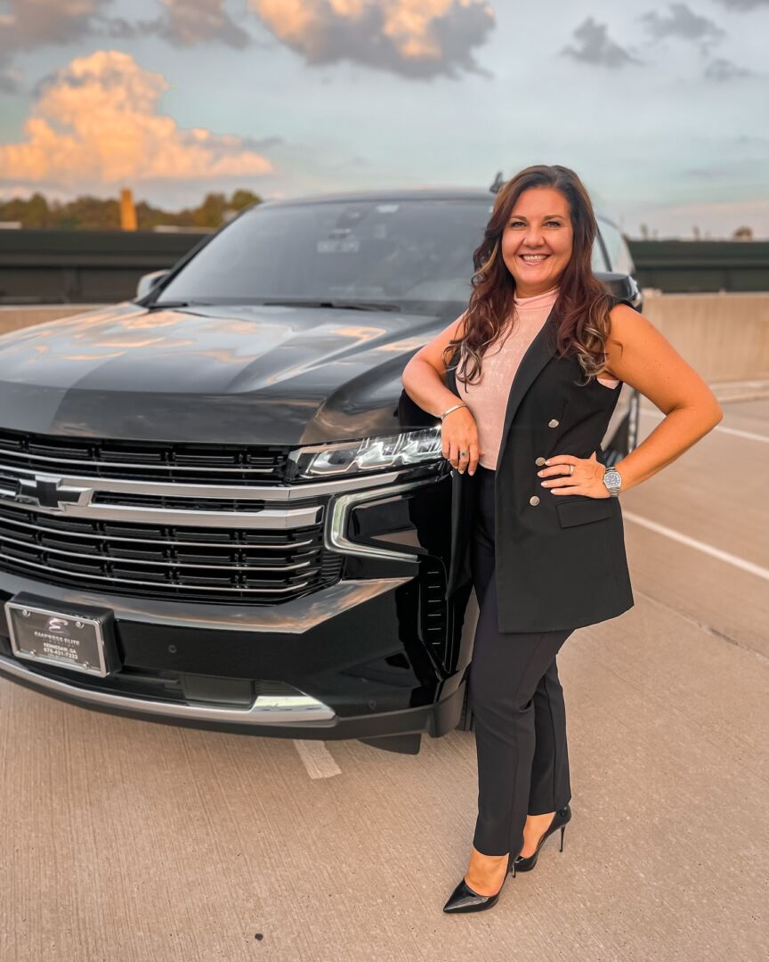 Maria Priestly, founder of Empress Elite Limousine, with a Suburban SUV chauffeur vehicle in Atlanta